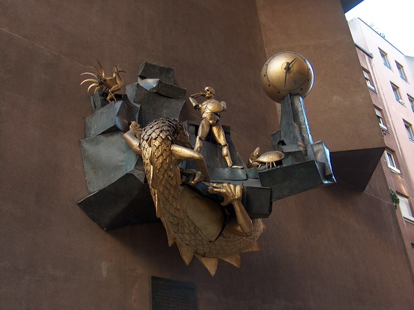 this animated clock symbolizing human's battle against the earth (dragon), the air (bird), and the water (crab)