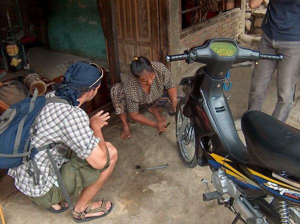 Hlad píchl přední kolo. Zastavujeme u servisu a ptáme se paní, kde má manžela, jestli by to opravil... Paní místo toho sama sundává duši...