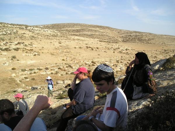 Dozvídáme se, že na místě je skupina křesťanských dobrovolníků, která se dostala do střetu s armádou. Jeden z dobrovolníků je obviňen z napadení vojáka a hrozí mu zatčení. Orání je zastaveno a všichni čekají, jestli se podaří vyjednat propuštění dobrovolníka