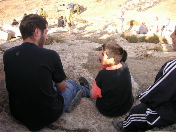 Itamar si krátí chvíli povídáním s palestinským klukem