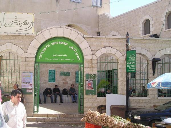 Muslimští muži odpočívající před mešitou během pátečních modliteb/Muslim men resting on a mosque yard during the Friday prayers