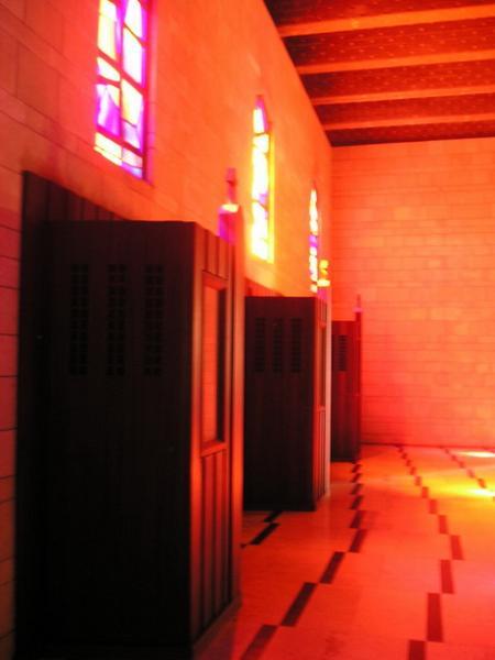 Bazilika má krásná mozaikovitá okna, která do kostela vnáší krásně barevné světlo (řada zpovědnic)/The basilica has beautiful mosaic windows which color the incoming light (a row of confessionals)