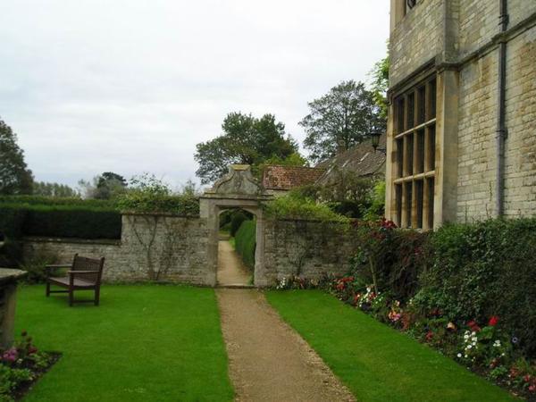 A kolem něj je spousta kytek a zídek (velmi britské)/It is surrounded by all kinds of bushes, lawns and stone walls (how British)