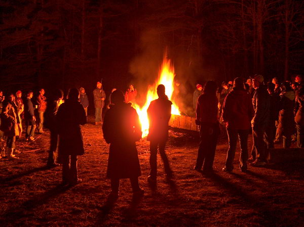Kuleho teorém platí i zde: poloměr kruhu stojících lidí lze regulovat pomocí množství dříví v ohni