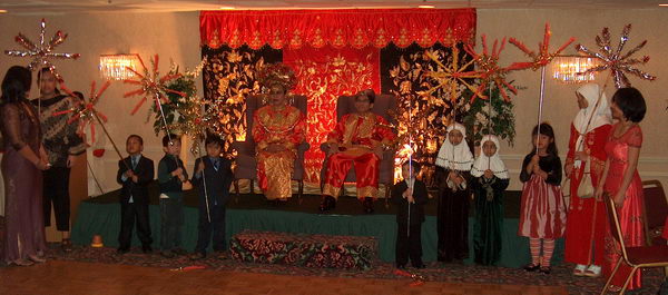 The couple sits on a podium...