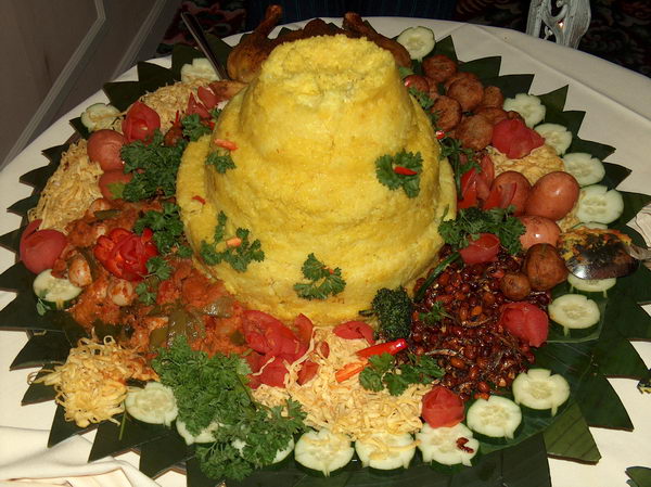 ...a gigantic pile of yellow rice calles nasi tumpeng, with many side dishes. The tradition resembles Western wedding cakes, but it's healthier, I guess;-)