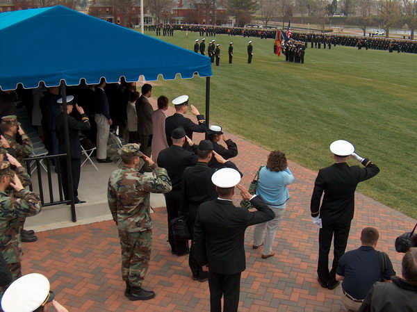 Vojenský personál salutuje k vlajce